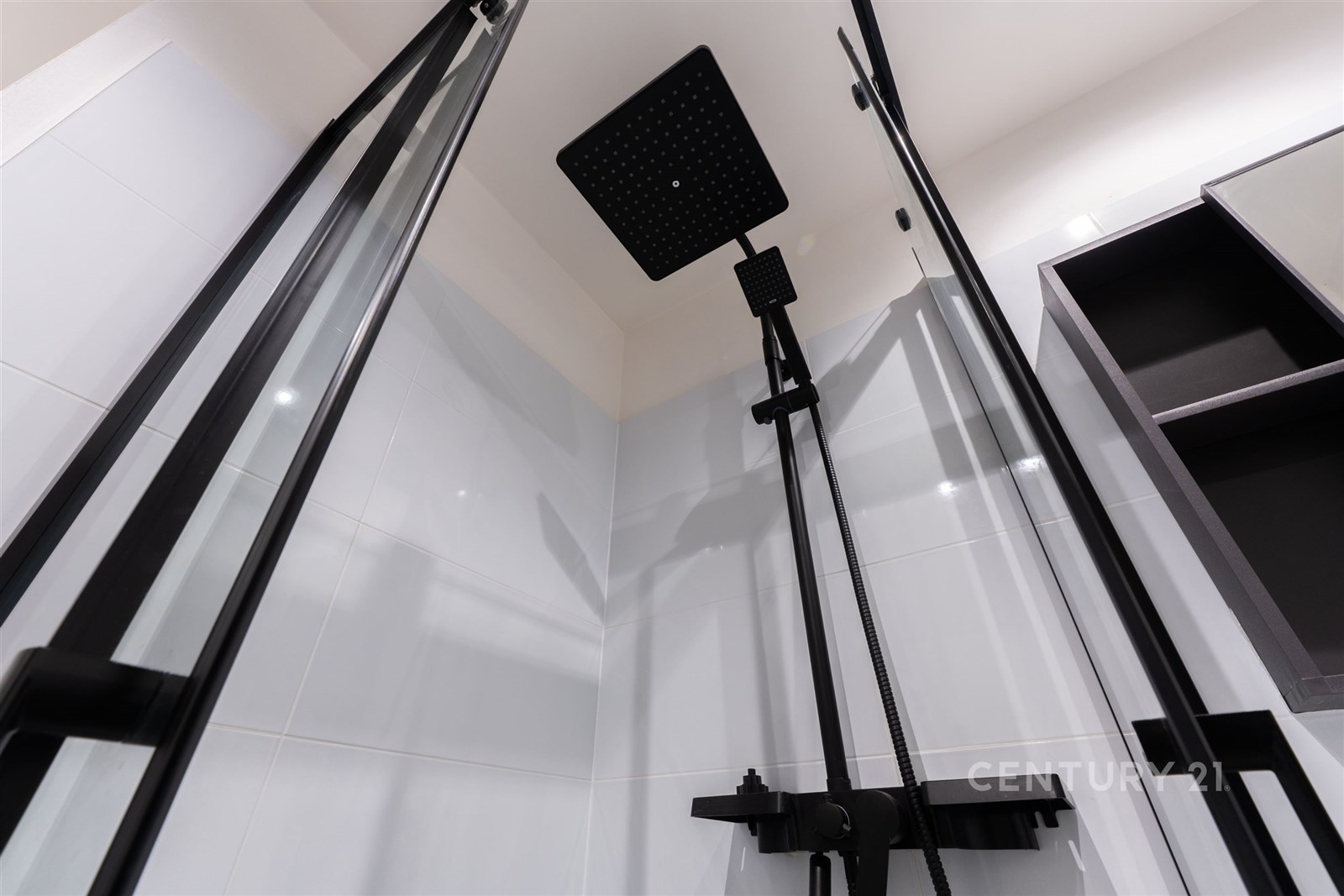 Moderní sprchový kout s černými skleněnými dveřmi,