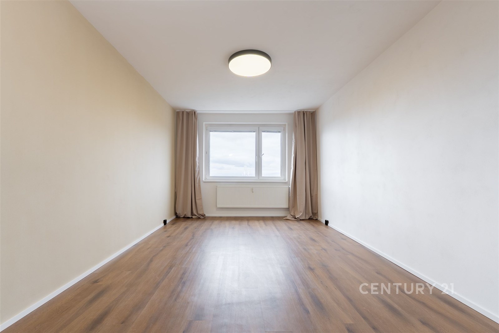 Prostorná ložnice s parketovou podlahou, velké okn