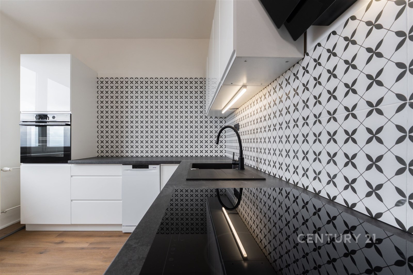 Moderní kuchyň s černobílou dlažbou, vestavěnými s