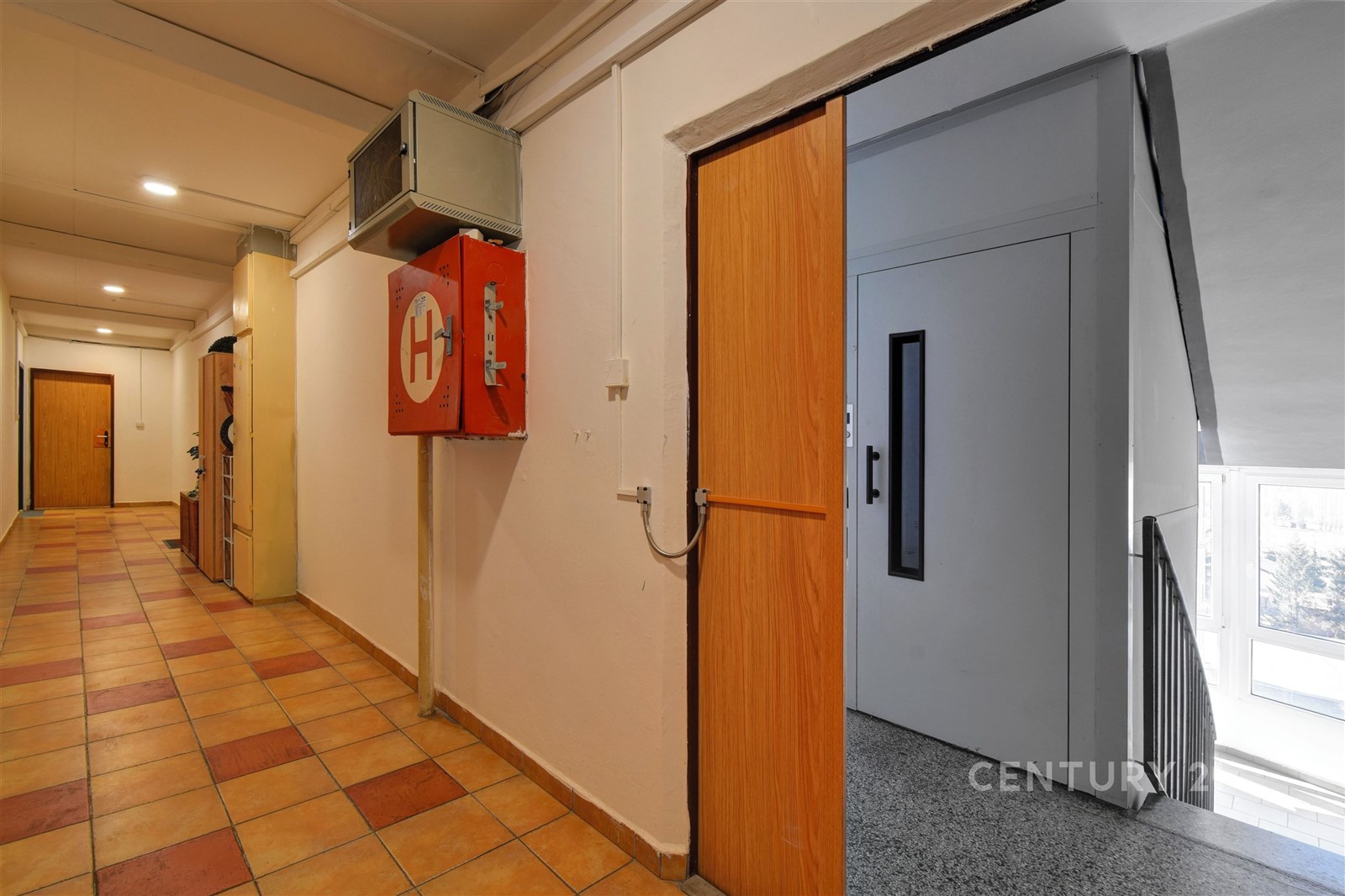 Společná chodba v bytovém domě s dlažbou na podlaz