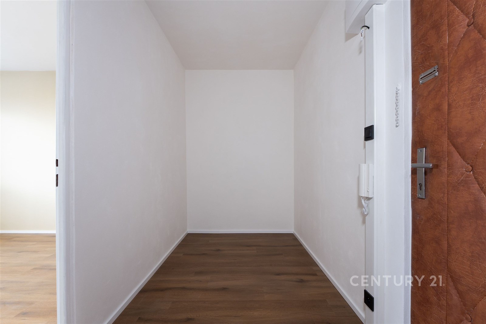 Vstupní chodba s dřevěnou podlahou, čisté bílé stě