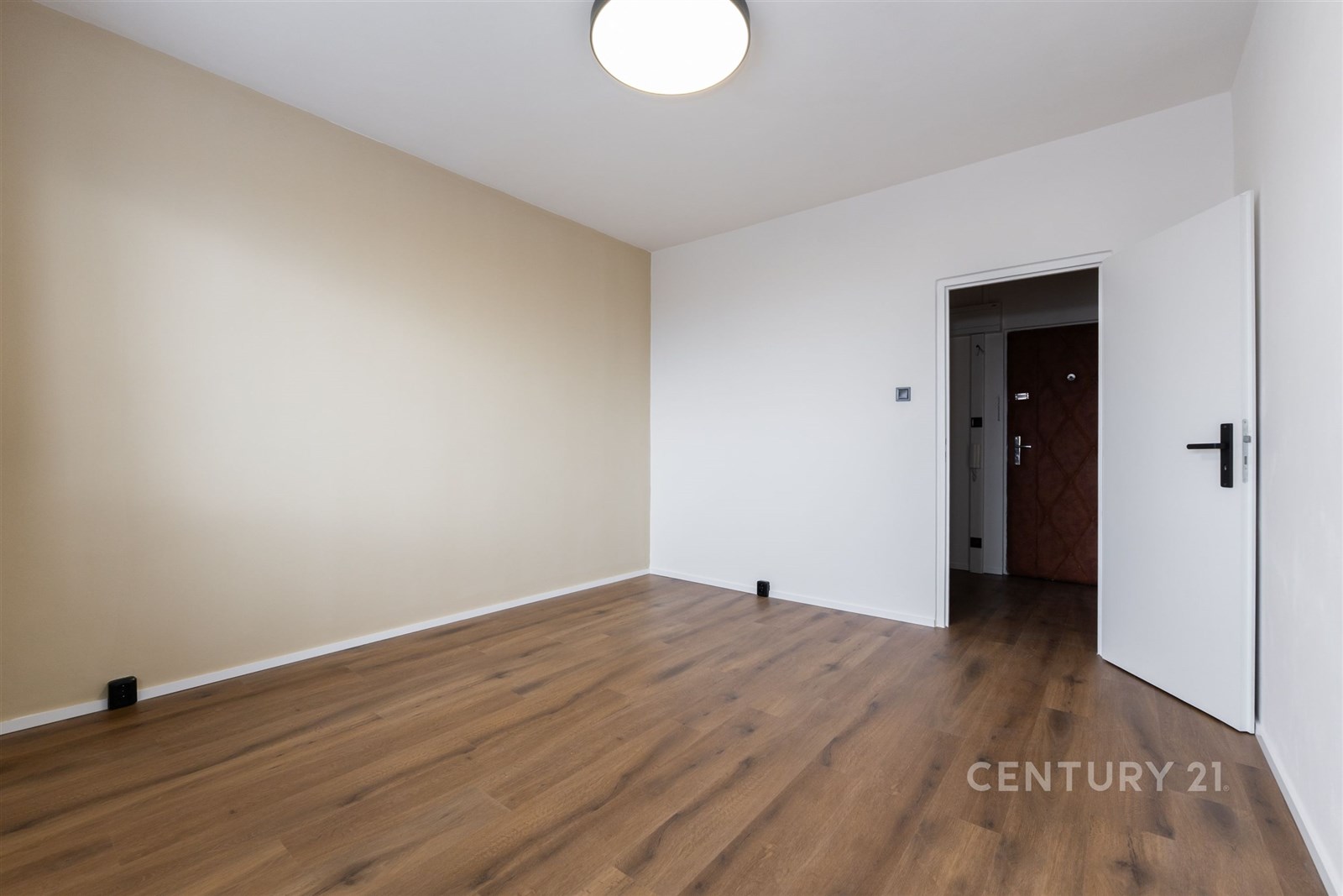 Prázdná místnost s dřevěnou podlahou, světlými stě