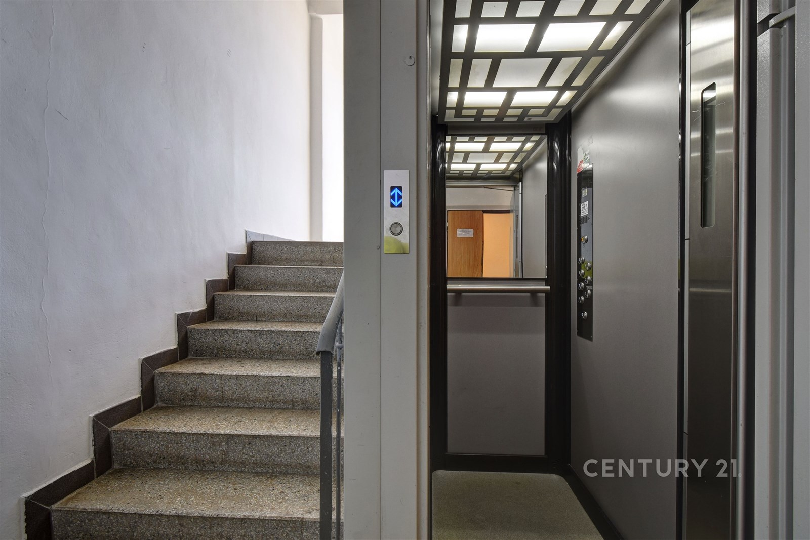 Vstupní prostor s moderním výtahem a kamennými sch