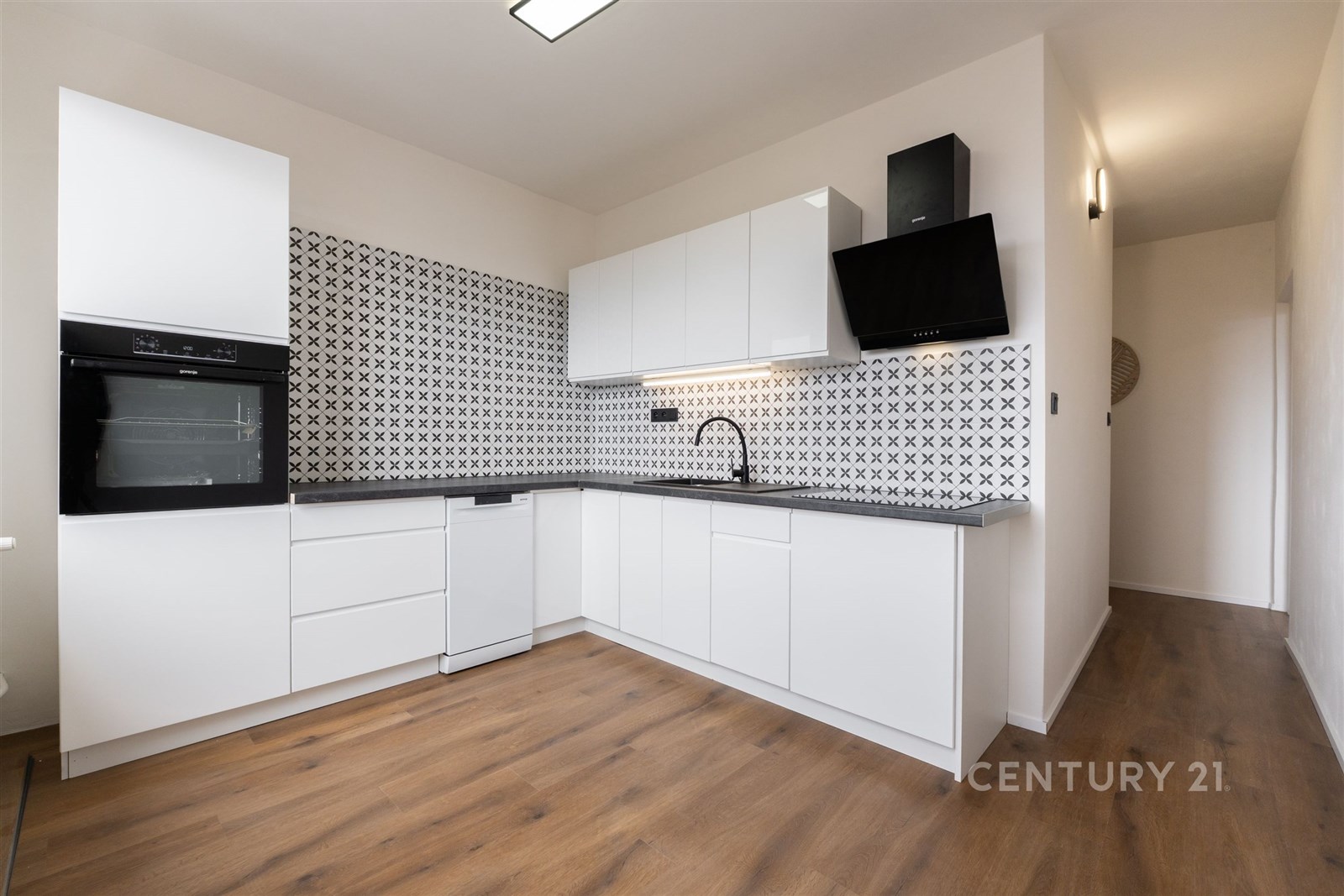 Moderní kuchyň s bílými skříňkami, parketovou podl