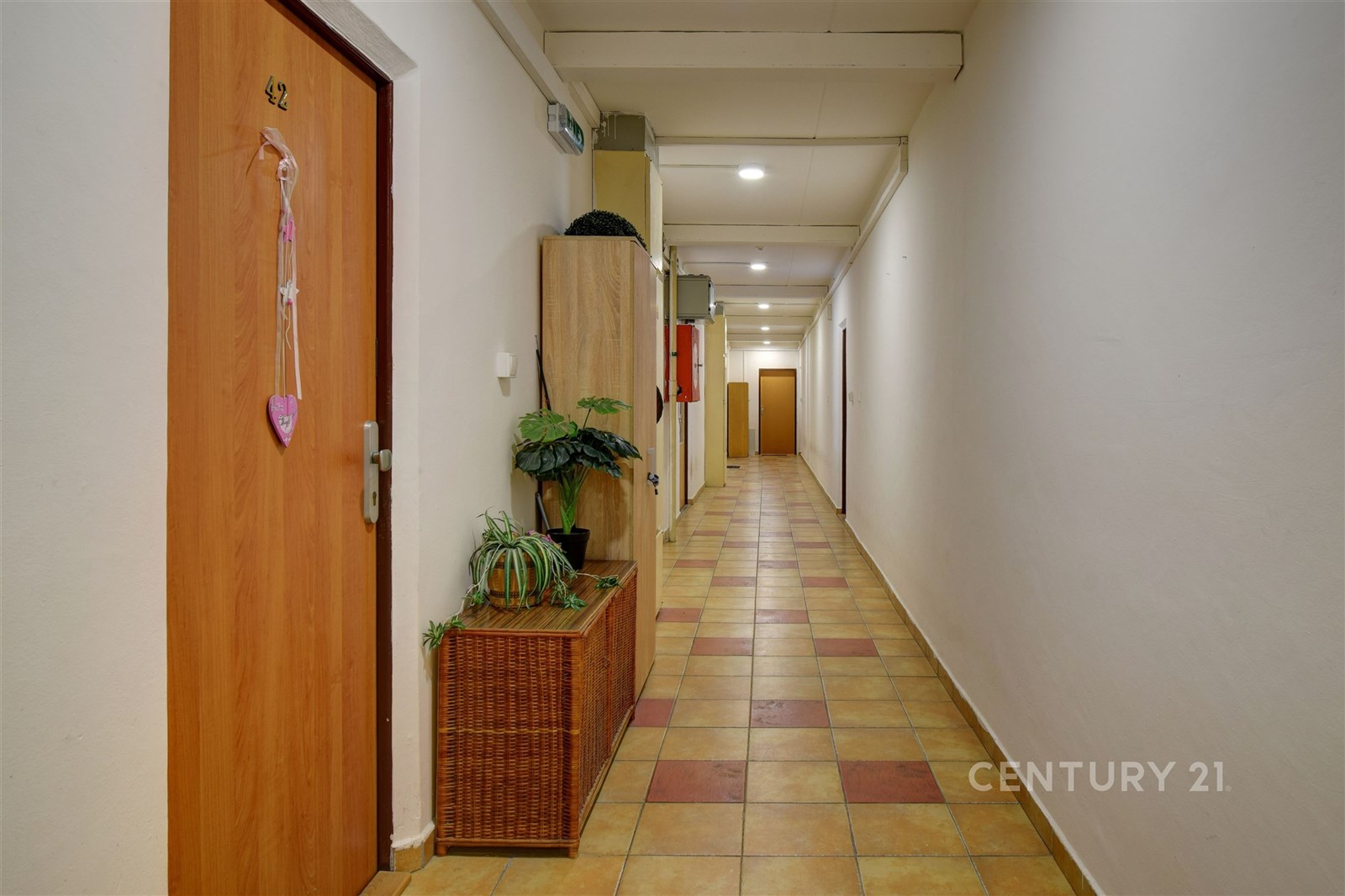 Chodba s dlažbou, světlé stěny a vestavěné skříně,