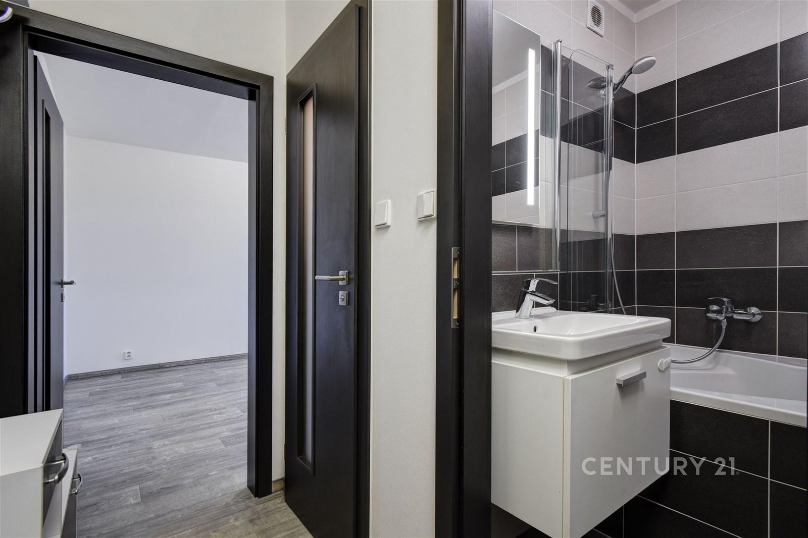 Koupelna s moderními dlaždicemi, sprchou a vanou. 