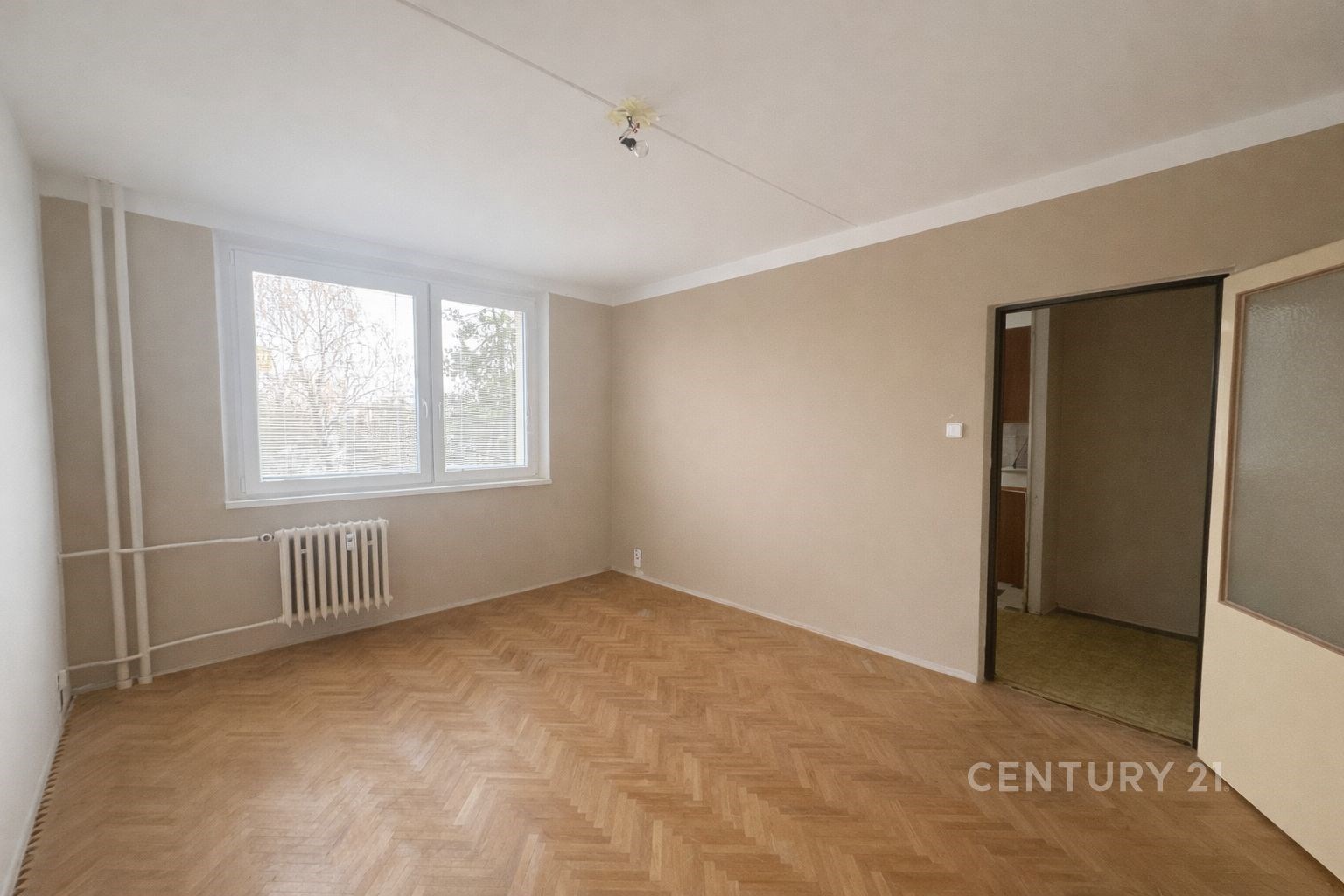 Světlý obývací pokoj s parketovou podlahou, velkým