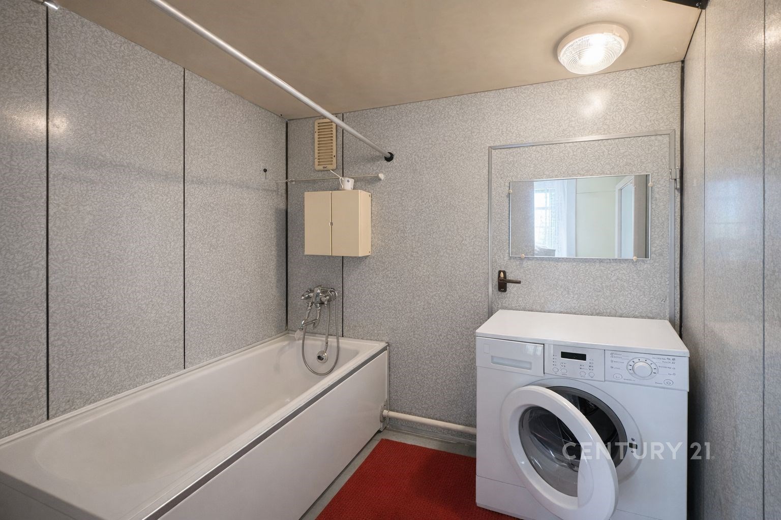 Koupelna s vanou, pračkou a vestavěnou skříňkou, s