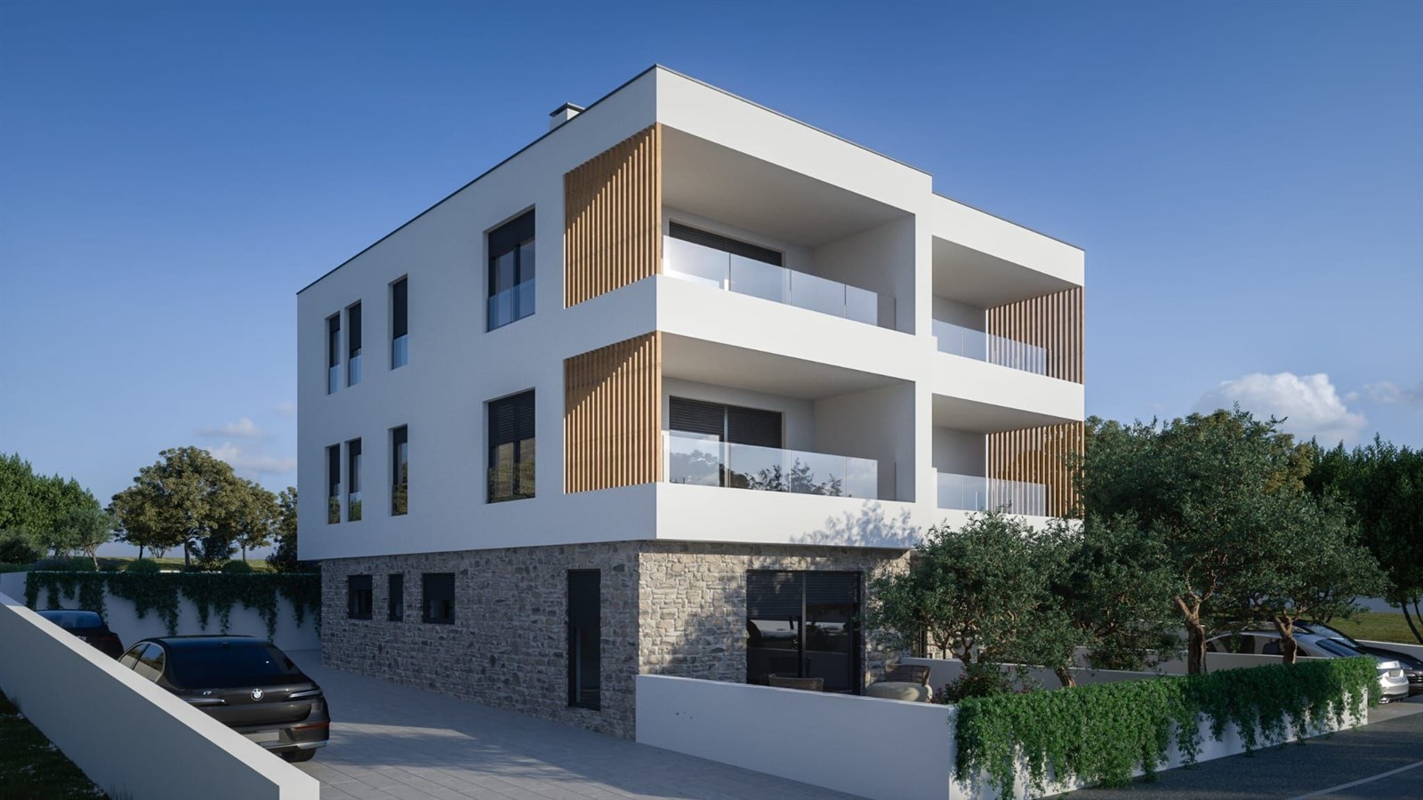 Moderní bytový dům s elegantní fasádou, dřevěnými obklady a velkými balkony, obklopený upravenou zelení a parkováním.