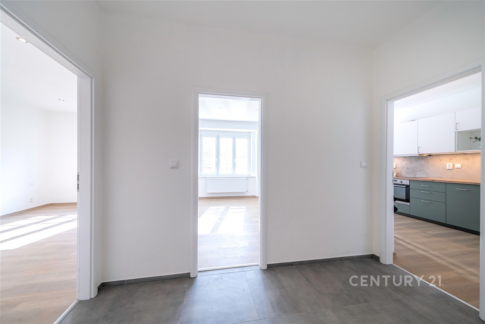 Prostorná chodba s dlažbou, vede do světlého obýva