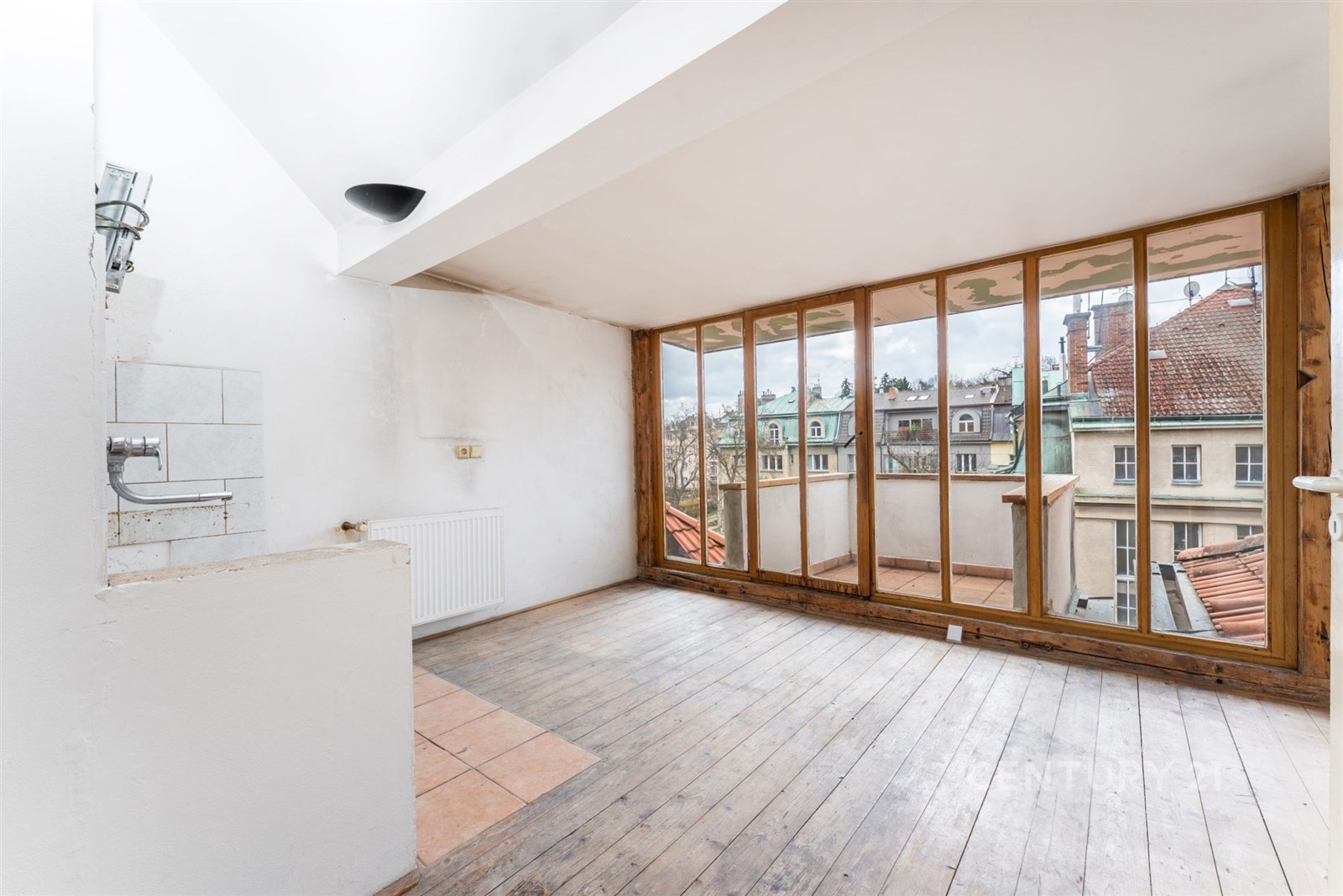 Podkrovní místnost s dřevěnými podlahami a velkými