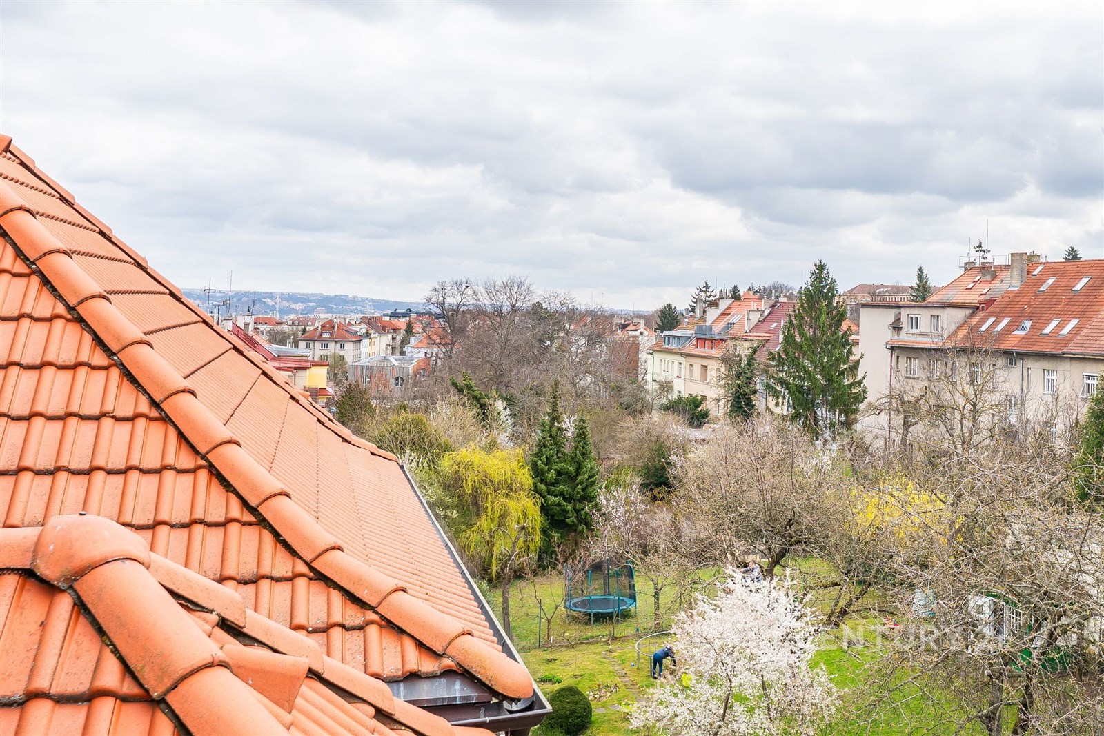 Výhled z podkrovního bytu na klidnou rezidenční čt