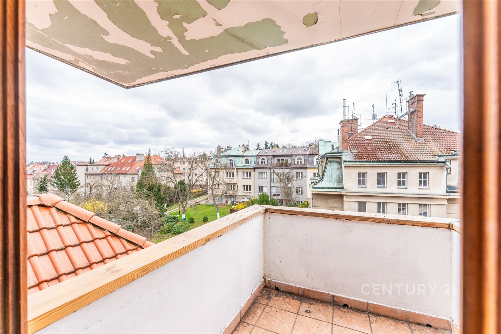 Výhled z balkónu s dlažbou a rustikálním zábradlím