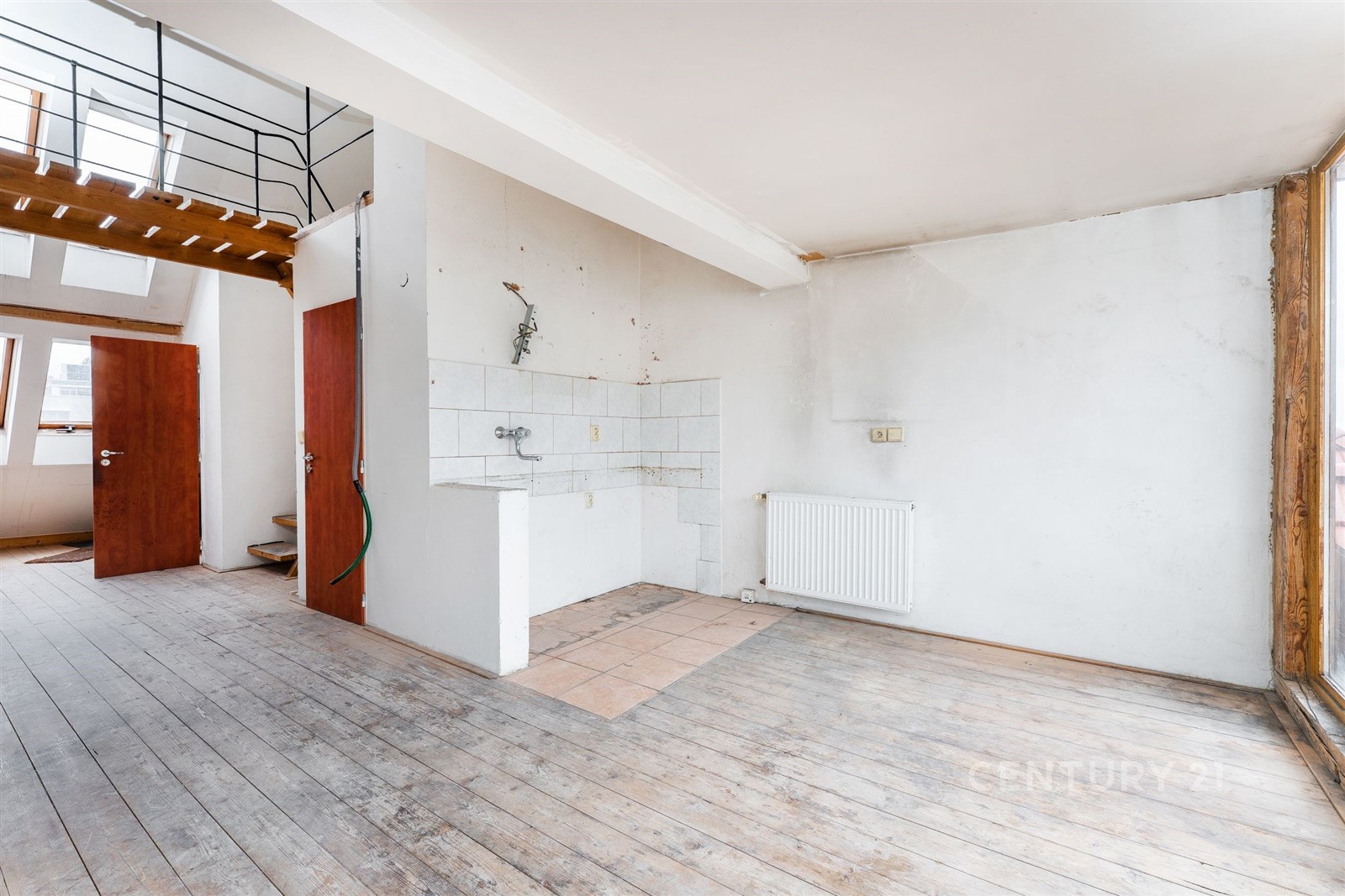 Prázdná kuchyň s dřevěnou podlahou, bílými stěnami