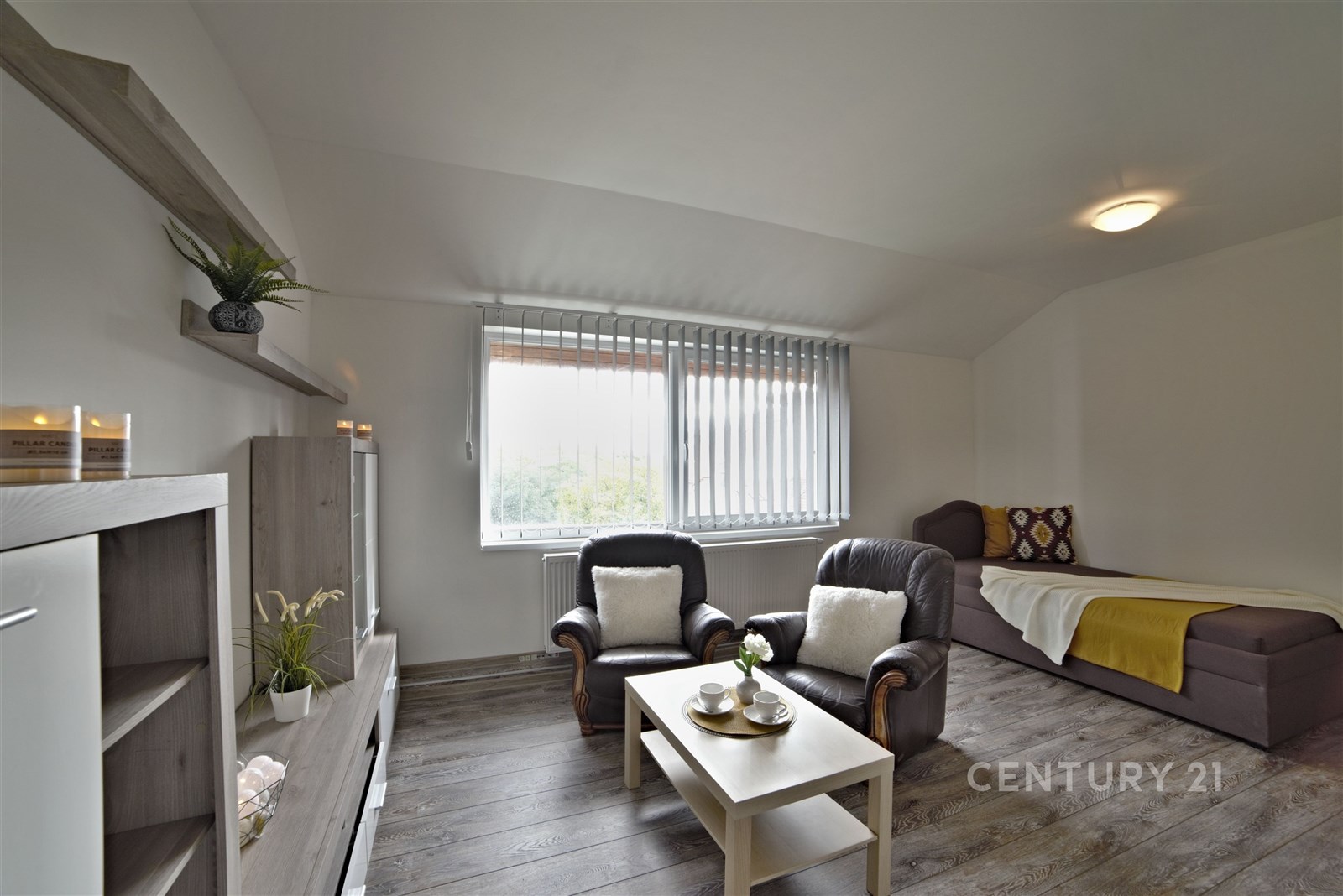 Světle zařízený obývací pokoj s parketovou podlaho