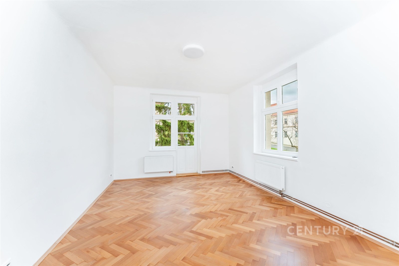 Světlý obývací pokoj s parketovou podlahou, velkým