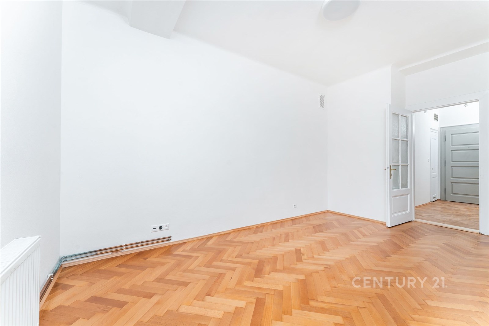 Světlý obývací pokoj s parketovou podlahou a bílým