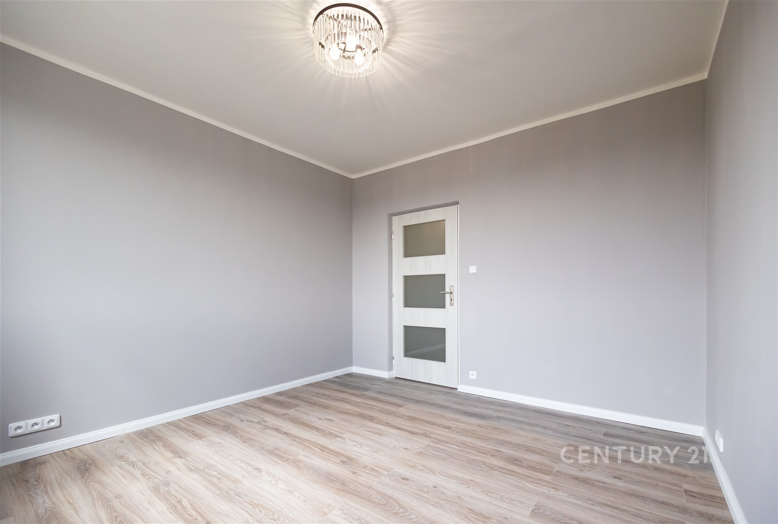 Světlá ložnice s moderní parketovou podlahou a elegantními bílými dveřmi, nově rekonstruovaná v neutrálních tónech pro elegantní vzhled.