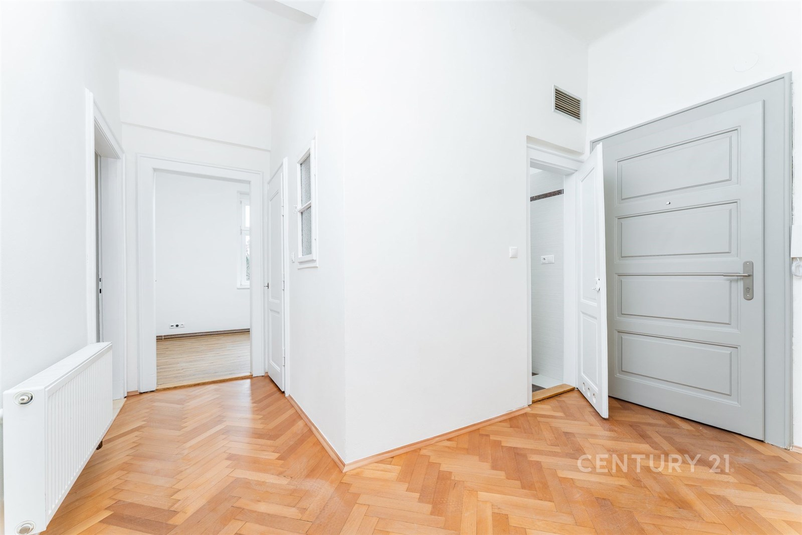 Prostorná chodba s parketovou podlahou a moderními