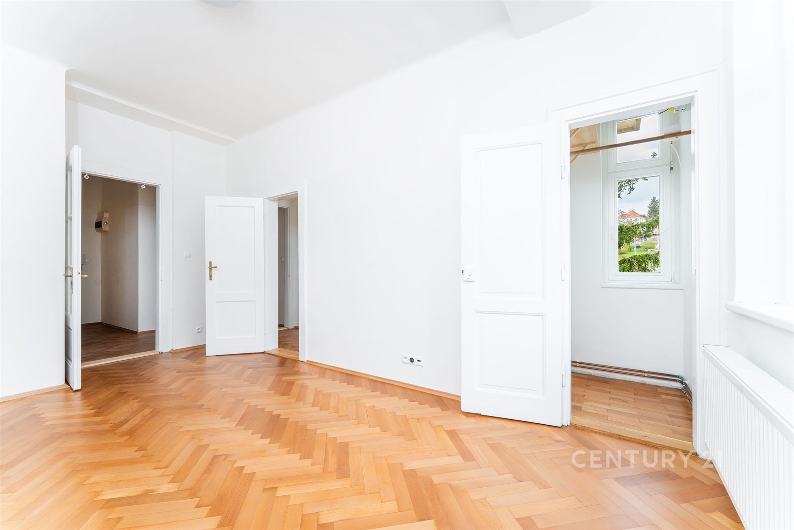 Světlý obývací pokoj s parketovou podlahou a bílým