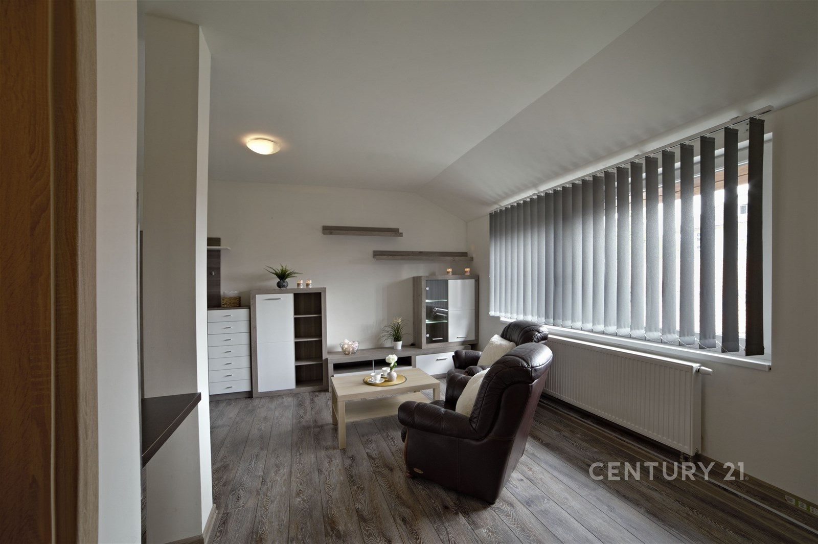 Světlý obývací pokoj s parketovou podlahou a velký