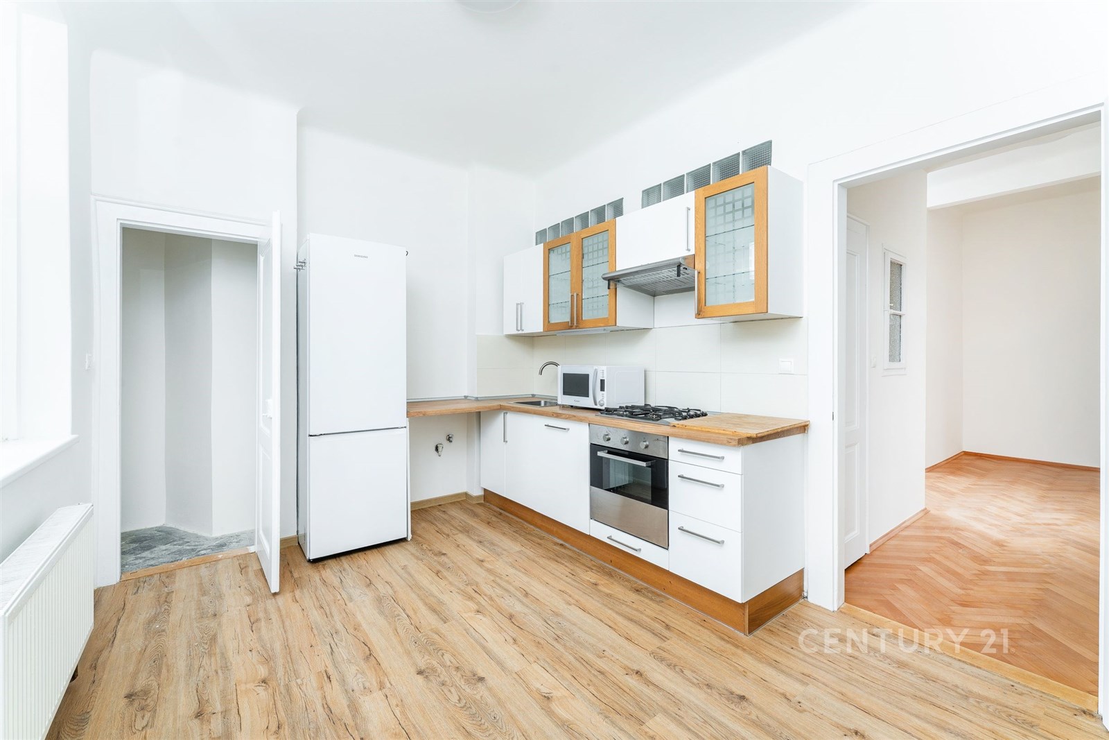 Světlá kuchyň s parketovou podlahou, moderními spo