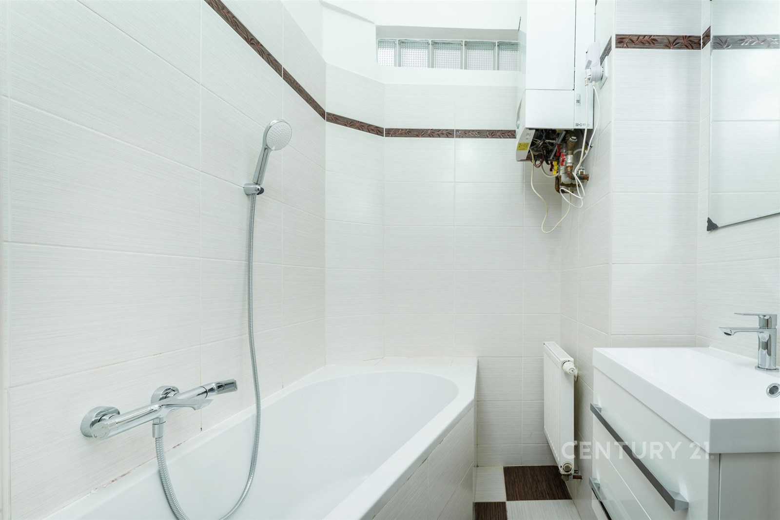 Moderní koupelna s bílými dlaždicemi, vanou a sprc