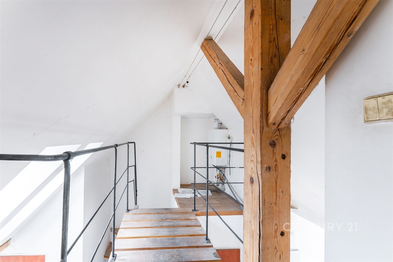 Podkrovní prostor s dřevěnými trámy, moderní kovov