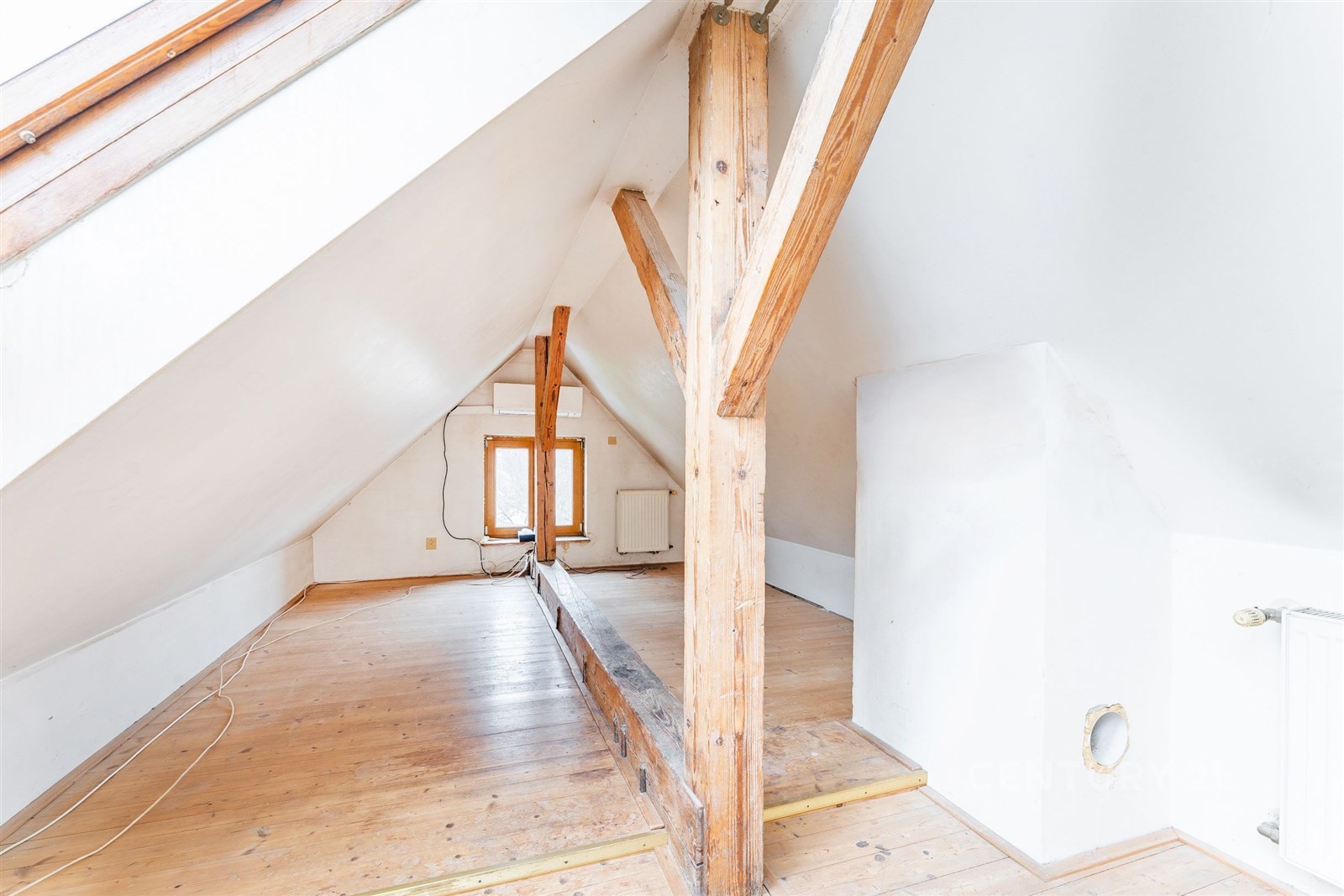 Podkrovní prostor s dřevěnou podlahou a trámy, svě