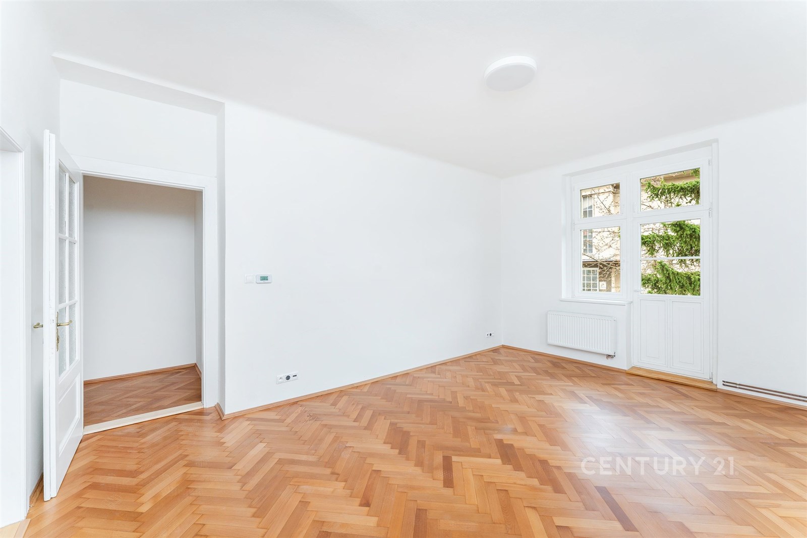 Světlý obývací pokoj s parketovou podlahou, bílými