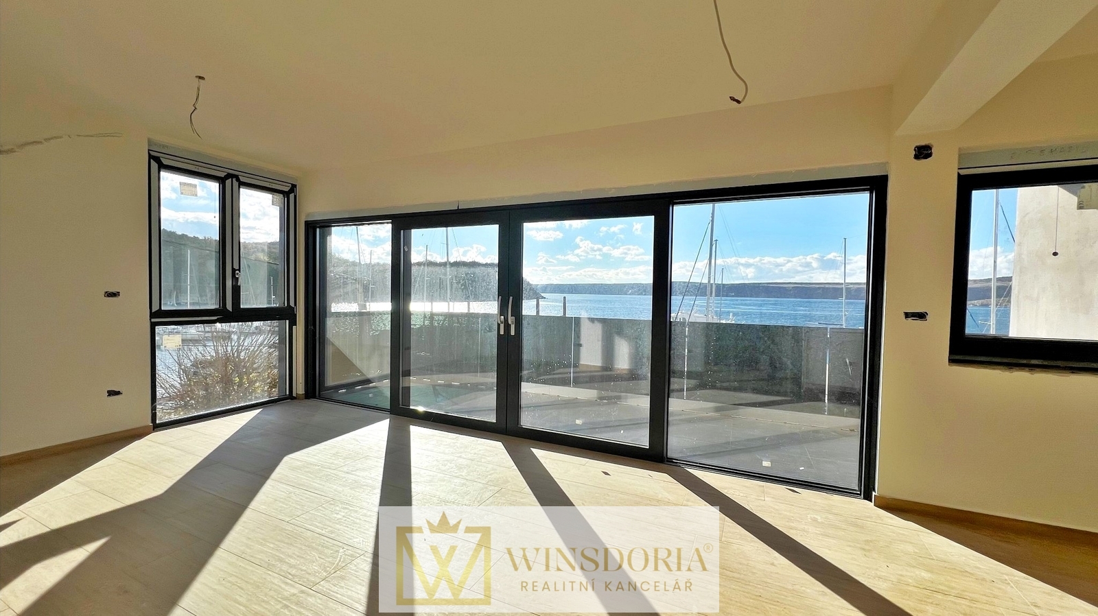 Prostorná ložnice s velkými okny