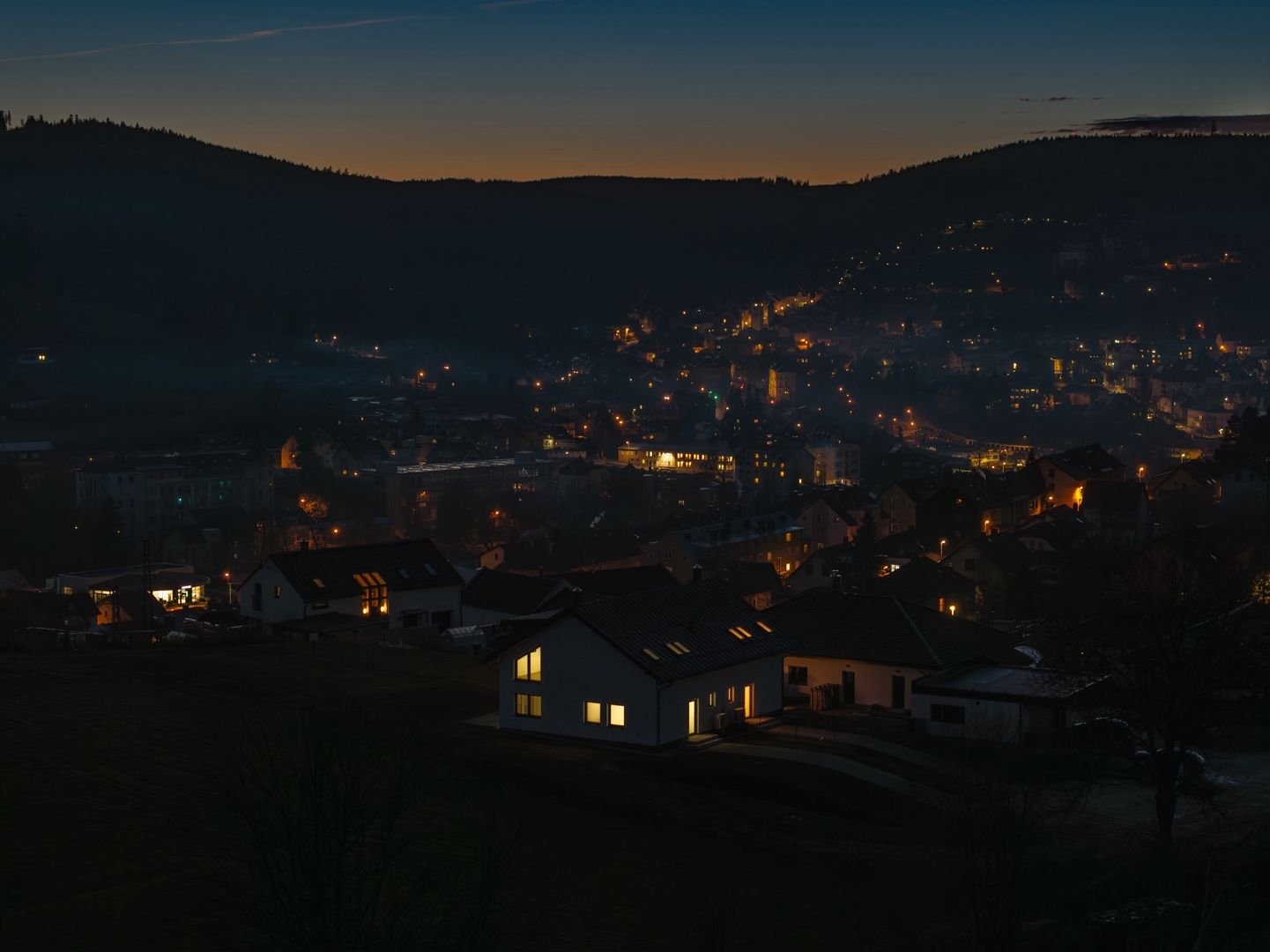 Osvětlený dům v noci s Vimperkem v pozadí