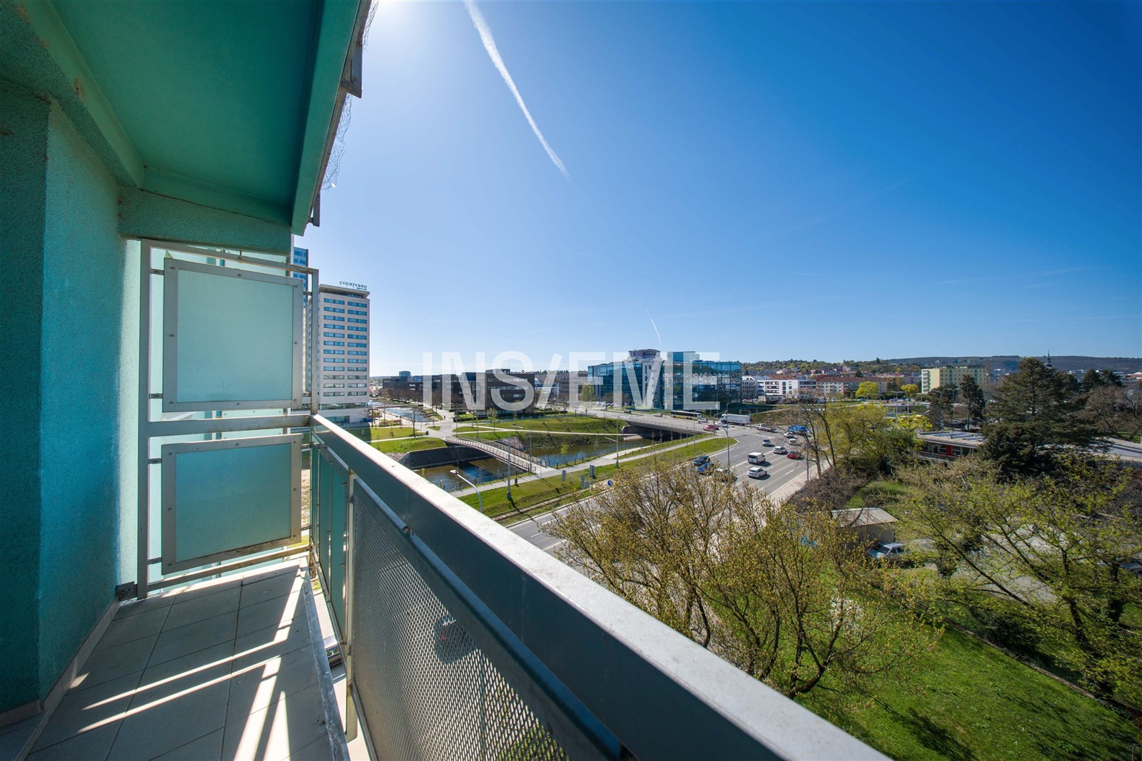 Balkón s moderní dlažbou nabízí panoramatický výhled na město. Prostorný a vzdušný prostor je ideální pro relaxaci a užívání slunečných dní.