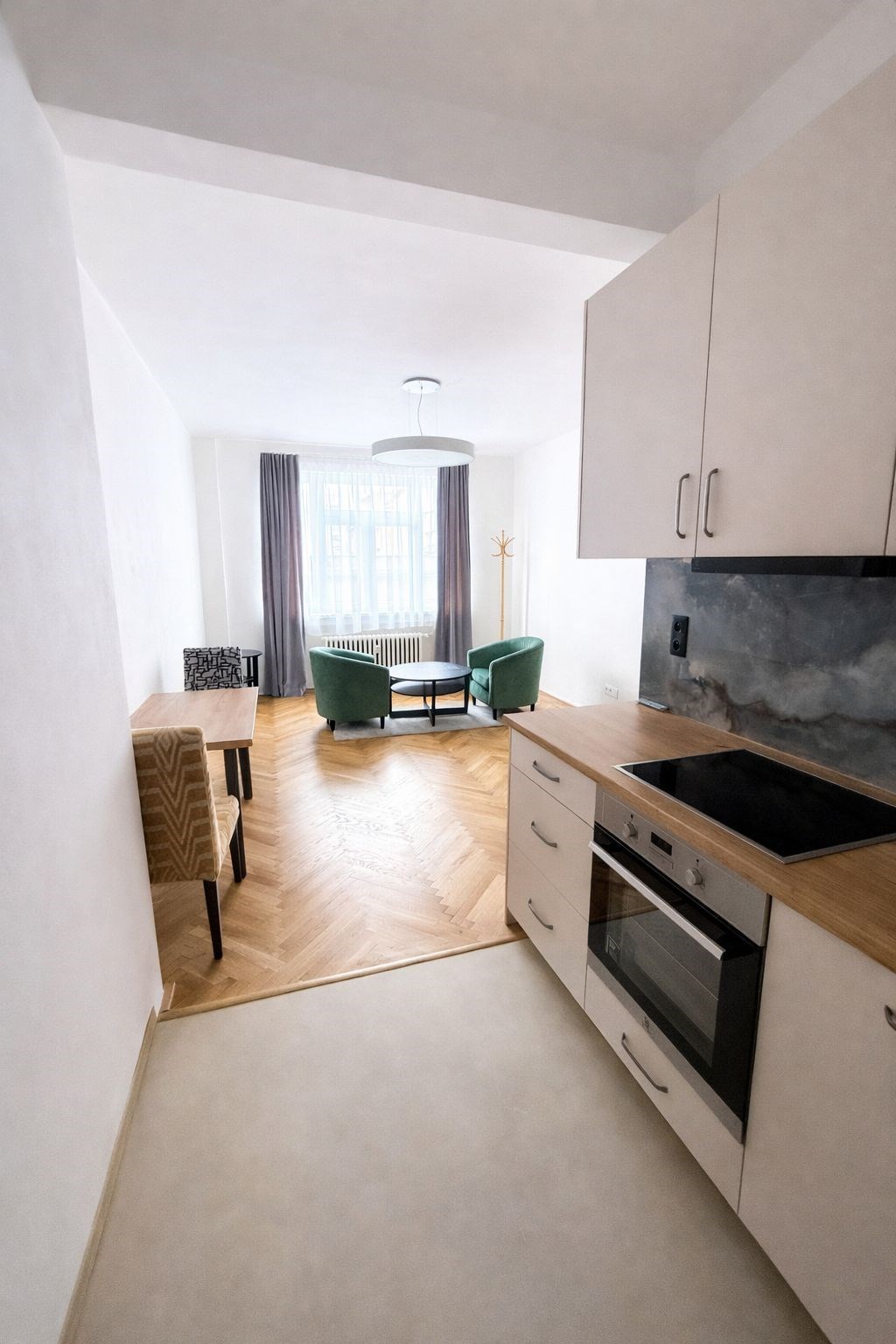 Kompaktní kuchyň s moderními spotřebiči, parketová