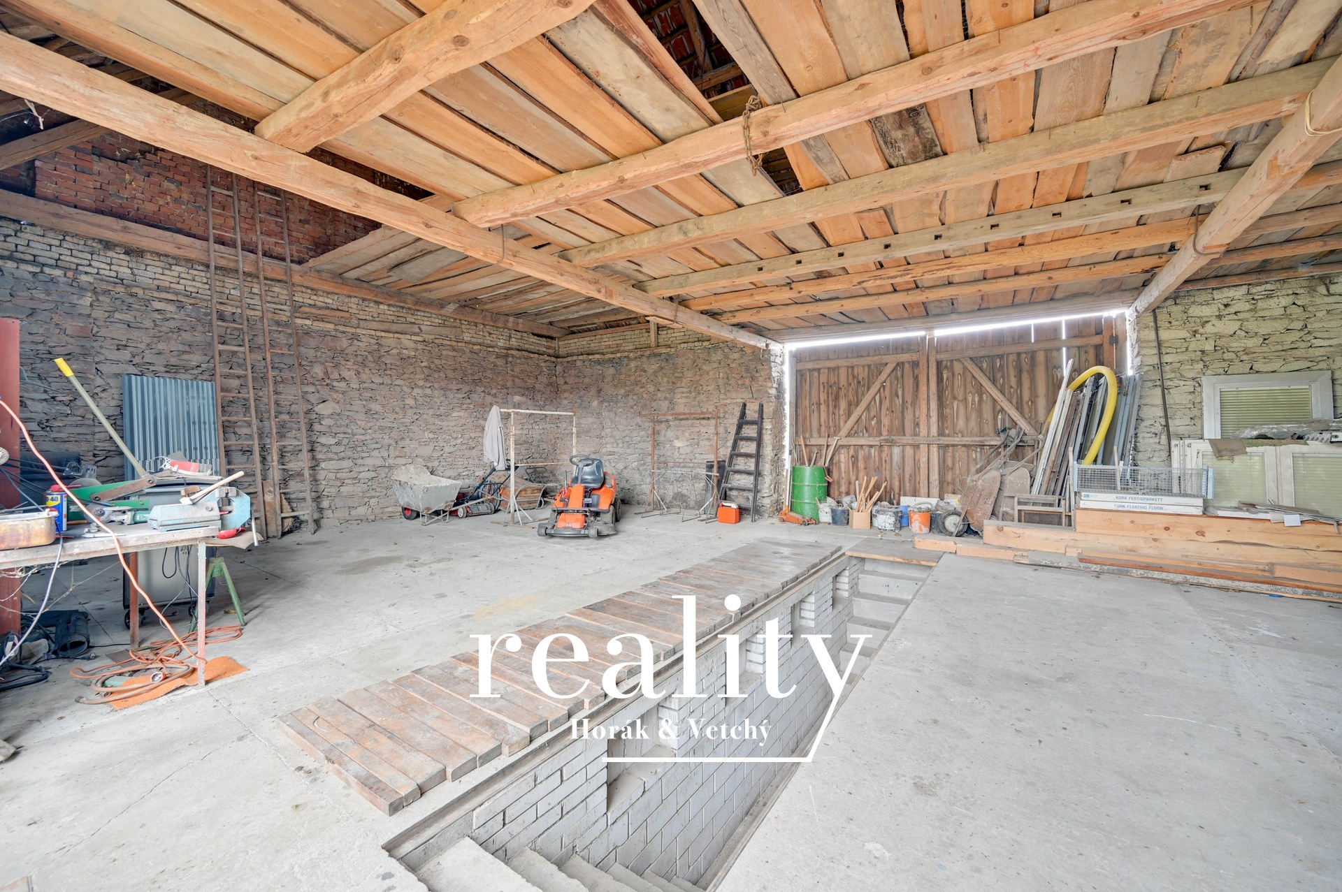 Vnitřní prostor ve stodole s montážní jámou