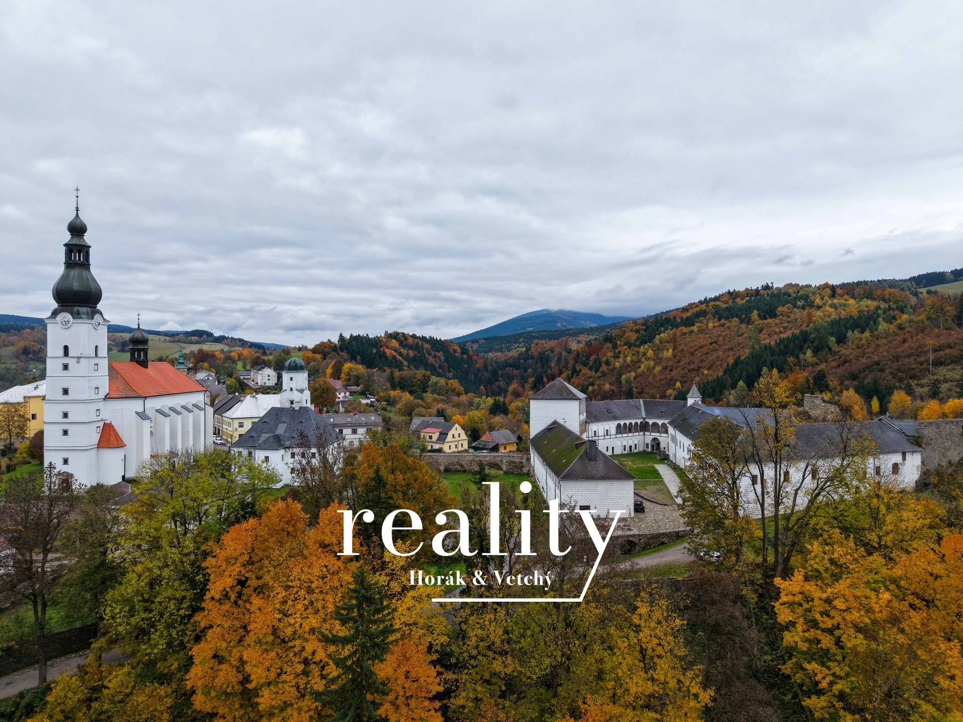 Výhled z pozemku na zámek Kolštejn a kostel sv. Mi